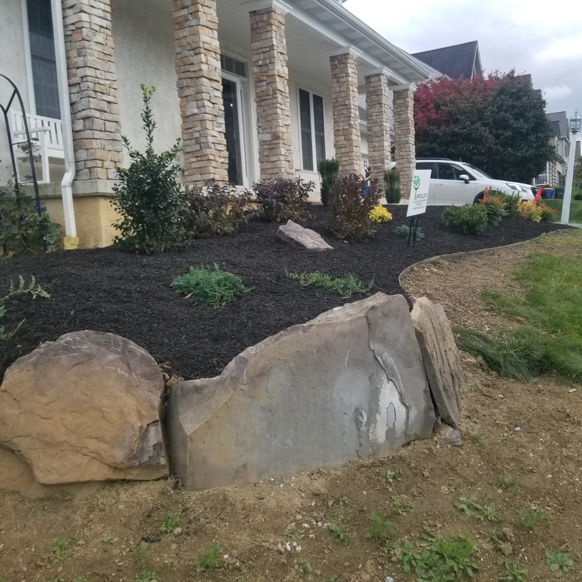 Cleaned garden in York PA with fresh mulch, no weeds, and large decorative rocks for visual appeal
